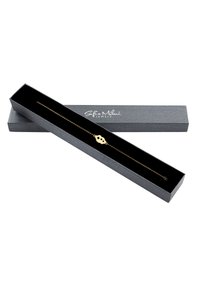 Bracciale in catena d'oro in una scatola grigia foderata in velluto nero, presenta un ciondolo ovale con tre fori a forma di stella e una chiusura a gancio di tipo granchio.