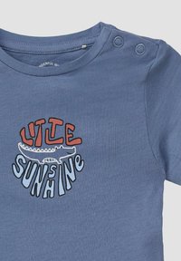 Blauw shirt met korte mouwen en een ronde halslijn, voorzien van een grafisch ontwerp van "LITTLE SUNSHINE" en een illustratie van een alligator in contrasterende kleuren.