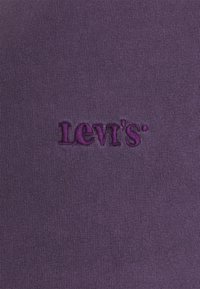 Purple cotton fabric featuring the embroidered "Levi's" logo in a slightly darker shade of purple. Texture is smooth with a tight-knit pattern.