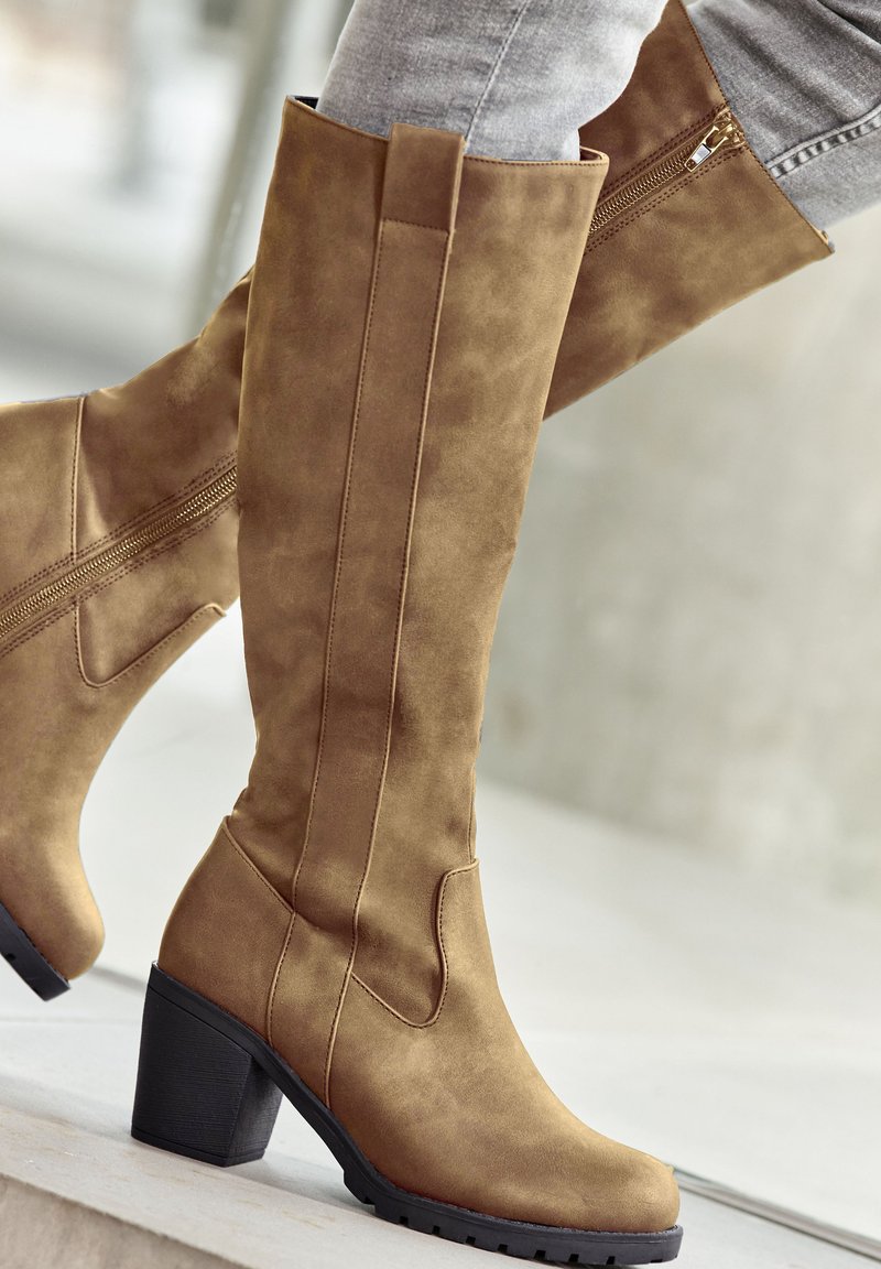 Knee-high brown faux suede boots with a block heel, featuring a zipper on the side and a smooth texture, ideal for casual wear.