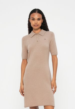 Strick-Polo-Kleid in Hellbeige mit kurzen Ärmeln, drei-Knopf-Leiste und kleinem Logo-Detail auf der Brust. Glatte Textur.