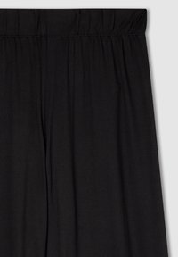 Pantaloni neri con elastico in vita, realizzati in un tessuto morbido e leggero. Presentano una texture liscia e una vestibilità ampia e rilassata.