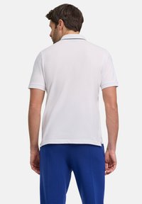 Biała koszulka polo z fakturowanej tkaniny, krótki rękaw i prosty design. Posiada klasyczny kołnierz i kontrastowe detale w szwach.