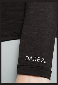 T-shirt de sport noir à manches longues avec une coupe ajustée. Il présente une texture lisse et un logo blanc 'DARE2B' près du poignet.