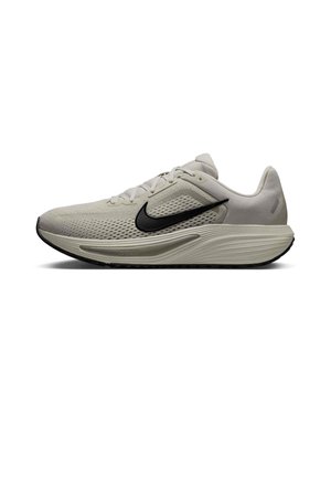 Zapatilla de running Nike de color gris claro con logo swoosh negro, parte superior de malla transpirable, entresuela acolchada y suela exterior negra con textura.