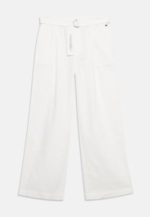 Pantalones blancos de pierna ancha con cinturón de tela y hebilla metálica, con un pequeño logo de bandera cerca de la cintura.