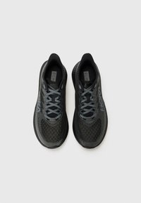 Zwarte sportieve schoenen met een gestructureerde mesh bovenkant en contrasterende grijze veters. Beschikt over een gevoerde kraag en een logo aan de zijkant. Veilige pasvorm met perforaties.