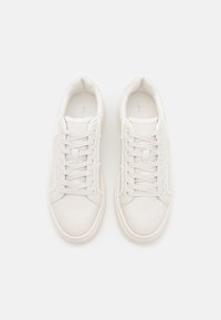 Bílé kožené tenisky se hladkým povrchem, kulatou špičkou a plochými tkaničkami. Minimalistický design s jemným logem na boku.