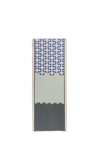 Tissu avec un motif géométrique de cercles et de lignes en bleu, rose et vert clair, avec des accents noirs et un bord frangé.