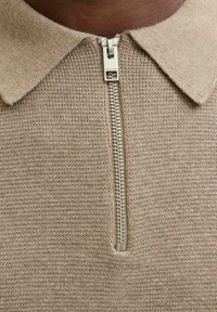 Artimas bežinės mezginio palaidinės, su sidabriniu užtrauktuku ir apykakle, užtrauktuko trauklė su įspaustu prekės ženklu "JACK & JONES."
