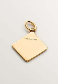 Colgante de metal color oro con forma de diamante, que presenta una superficie lisa y grabado "aristocrazy" en un lado. Incluye un lazo de sujeción circular.