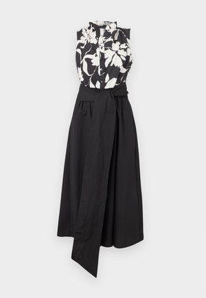 Αμάνικο φόρεμα με μαύρο και λευκό φλοράλ τοπ με κουμπιά και μαύρη μονόχρωμη φούστα, με φαρδιά ζώνη μαύρη που δένει στη μέση.