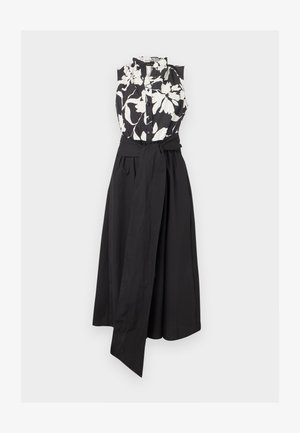 Αμάνικο φόρεμα με μαύρο και λευκό φλοράλ τοπ με κουμπιά και μαύρη μονόχρωμη φούστα, με φαρδιά ζώνη μαύρη που δένει στη μέση.