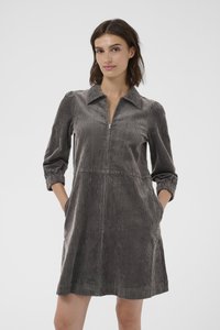 Abito di velluto a coste di colore grigio scuro con colletto, maniche lunghe a sbuffo, zip frontale e tasche laterali; tessuto testurizzato con righe verticali.