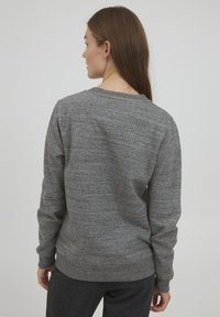 Grå bomullssweatshirt med rund hals, lange ermer og ribbede mansjetter, med en jevn tekstur og løs passform.