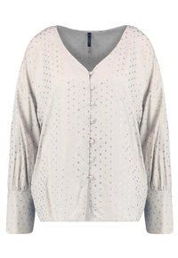 Blusa grigia chiaro con scollo a V, chiusura a bottoni e maniche lunghe. Presenta un motivo a pois in tonalità di rame metallico e oro rosa.