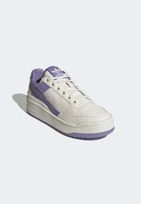White sneaker with lavender accents, smooth leather upper, perforated toe, lace-up design, padded collar, and textured rubber sole.