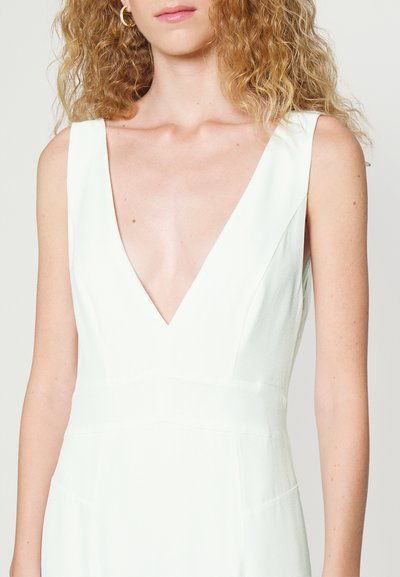 Vestido sem mangas verde claro com um decote em V profundo, feito de um tecido suave. Apresenta linhas limpas e um design minimalista.