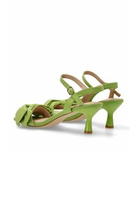 Sandalias verde de talón al descubierto con un diseño anudado en la parte delantera, acabado en charol y un tacón delgado en forma de cono. Correa ajustable en el tobillo.