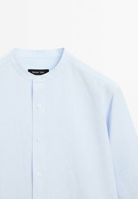 Camicia button-up blu chiaro con collo alla mandarina, realizzata in tessuto morbido, con una pattina con due bottoni e maniche corte.