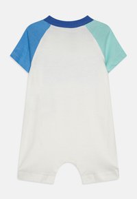 Kortermet baby romper i kremfarge med blå og tealfargede raglanermer, laget av myk bomull, og med rund halslinning. Har trykknapper nederst.