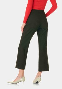 Gröna rutiga byxor med rak skärning, hög midja och sidoknappar. Matchas med ljusgröna spetsiga klackar. Röd ribbad topp.