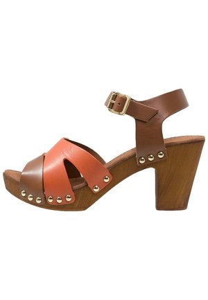 Brune og orange læder sandal med åben tå, træblokhæl, ankelrem, guldsnude og metalnitte detaljer.
