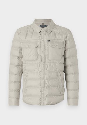 Padded beige jacket with a button-up front, two chest pockets, and a fold-down collar. Features horizontal quilted pattern and smooth texture.