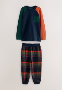 Ensemble de pyjama en coton composé d'un haut bleu marine avec des manches raglan vertes et orange et une poche poitrine, assorti à un pantalon à carreaux aux couleurs foncées.