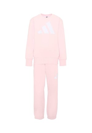 Set felpa e pantaloni della tuta rosa chiaro con logo Adidas bianco sul petto e sulla gamba sinistra, mostrato su sfondo bianco.