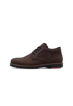 Bottine en cuir marron foncé avec lacets noirs, bout rond et semelle noire texturée avec un détail rouge près du talon.