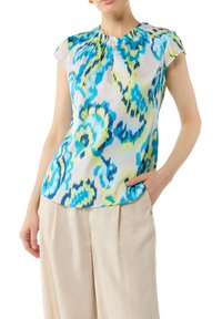 Kurzärmlige Bluse aus seidenähnlichem Material mit einem blau-grünen abstrakten Muster auf weißem Hintergrund. Rundhalsausschnitt, lockere Passform.