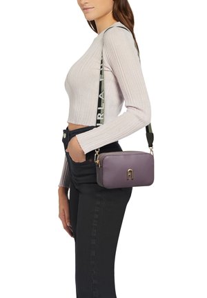 Purple leather crossbody bag with a rectangular shape, featuring a gold logo and a detachable strap with a green text design.