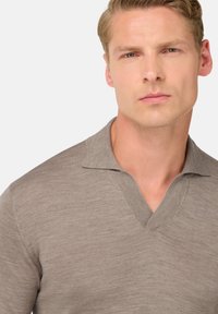 Hnědá polo košile s krátkým rukávem a designem do V, vyrobená z žebrované tkaniny. Měkká textura s jemným leskem.