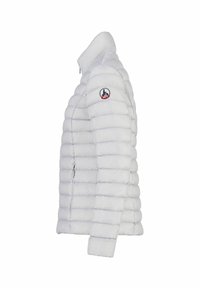 Chaqueta acolchada blanca con un diseño ajustado, patrón de acolchado horizontal, cuello alto y un parche con un logotipo redondo en la manga izquierda.