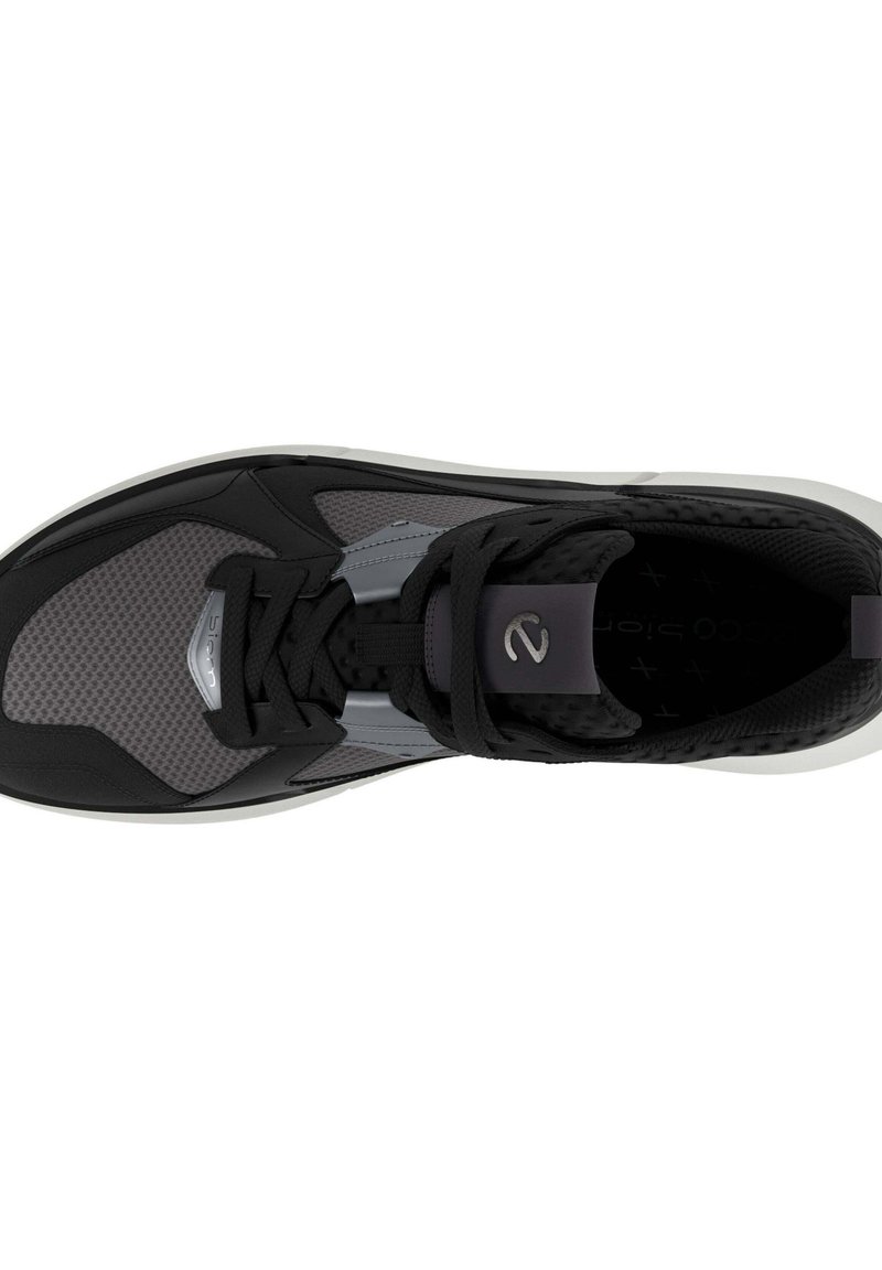 Schwarzer und grauer Sportschuh mit strukturiertem Obermaterial, Mesh-Einsätzen und einer dicken weißen Sohle. Beinhaltet schwarze Schnürsenkel und metallische Akzente.