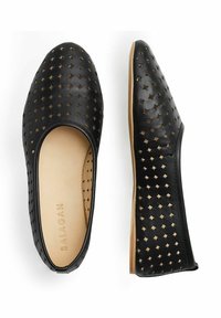 Zapatos planos de cuero negro con cortes en forma de diamante, puntera redonda y una plantilla de color beige suave. Diseño de suela flexible para mayor comodidad.