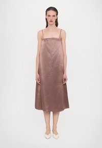 Ermeløs, midtlang kjole i et mykt mauve-stoff med en subtil glans og glatt tekstur, som har tynne stropper og en flytende silhuett.