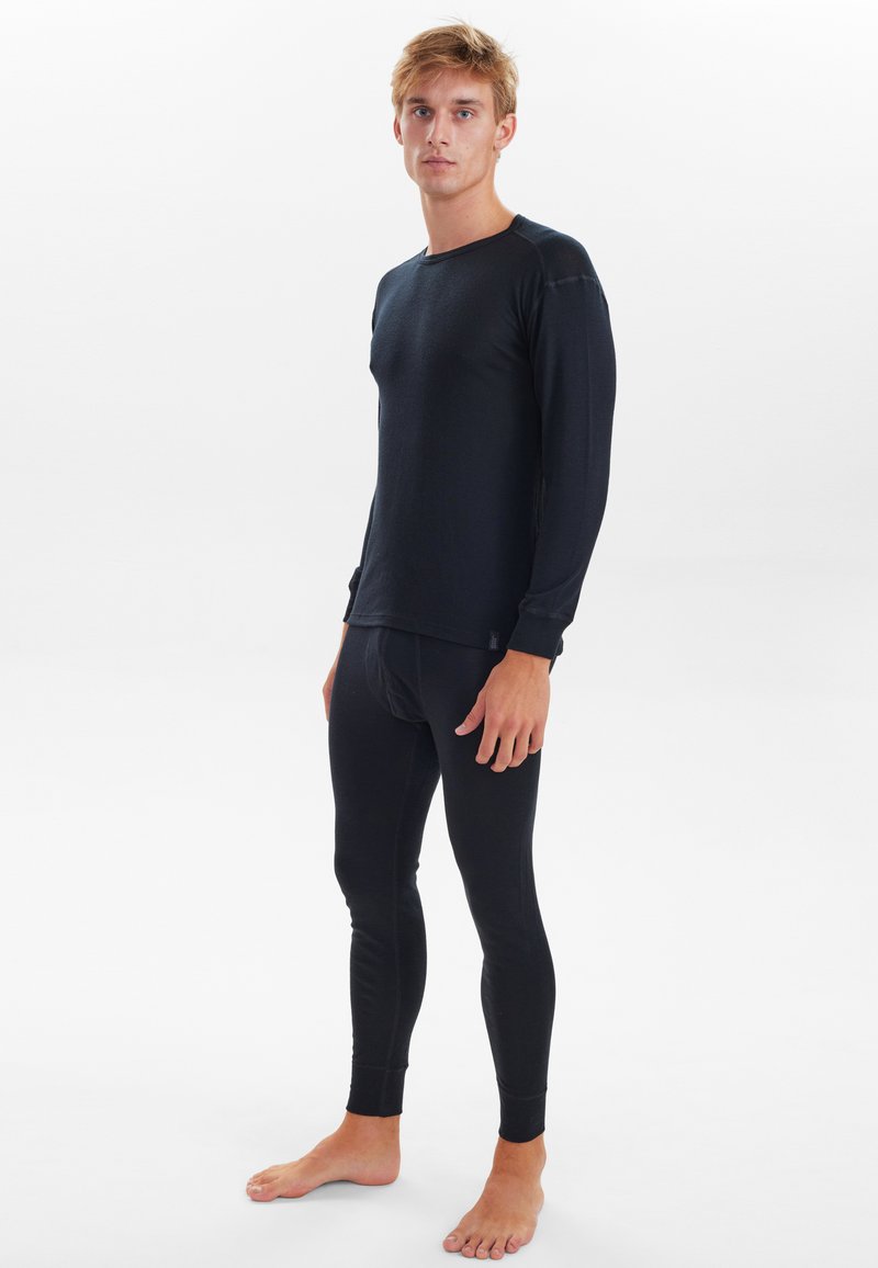 Black thermal long-sleeve top and fitted leggings. Soft fabric with a smooth texture, featuring a crew neck and cuffed sleeves.