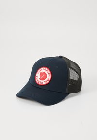 Marineblauwe en zwarte mesh truckercap met een rood en wit rond Fjällräven Zweden 1960 logo patch op het voorpaneel.