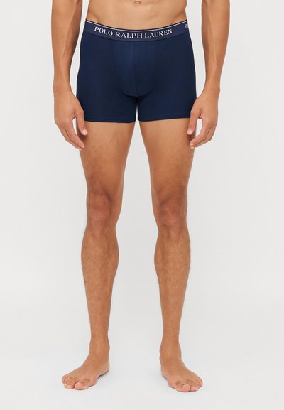 Boxer briefs masculinos em azul-marinho feitos de um tecido suave. Apresentam uma cintura elástica larga com o texto "POLO RALPH LAUREN" em cor contrastante.