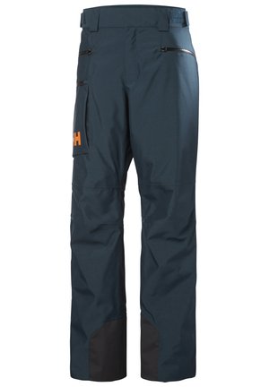 Pantalones impermeables azul marino con un dobladillo inferior negro, bolsillos con cremallera, cintura ajustable y un logo naranja en el lateral.