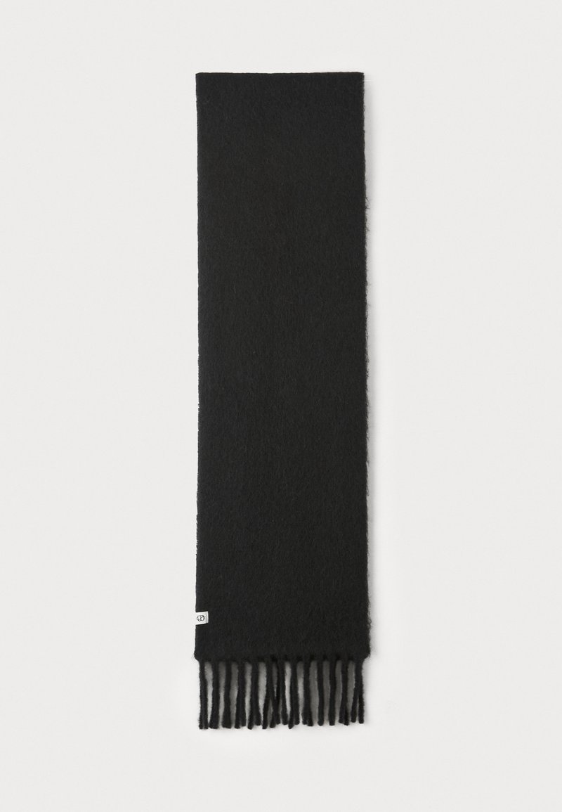 Écharpe noire en matériau doux, présentant une texture lisse et des franges aux extrémités. L'étiquette est visible d'un côté.