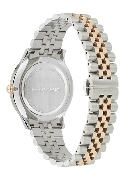 Zegarek ze stali nierdzewnej z bransoletą z metalowych ogniw w kolorze srebrnym i różowego złota. Okrągła koperta ma przezroczyste tylne szkło oznaczone napisem "Ferragamo".