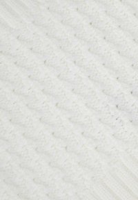 Tissu blanc texturé présentant une surface douce et duveteuse avec des motifs diagonaux et des accents nervurés. Le matériau semble épais et confortable.