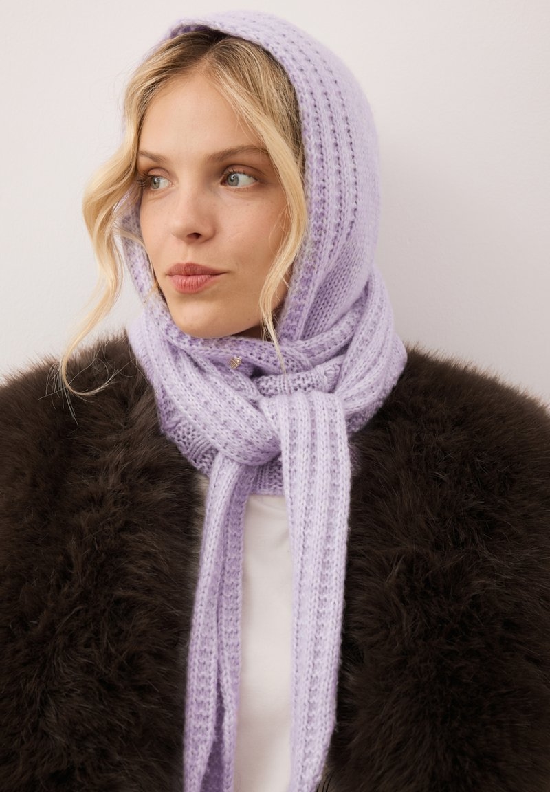 Lila gebreide sjaal met een geribbelde textuur, om de hals gebonden, met een zachte uitstraling en een subtiele glans, gedragen over een donker bontjas.