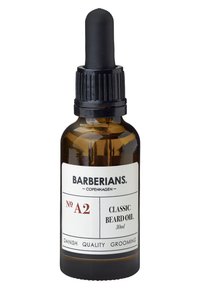Bouteille en verre ambre avec un compte-gouttes noir. L'étiquette blanche présente "BARBERIANS. COPENHAGUE" et le texte "HUILE À BARBE CLASSIQUE 30 ml".