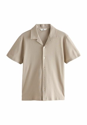 Chemise courte en beige clair à manches courtes avec un col rabattu, présentant un motif rayé texturé et cinq boutons sur le devant.