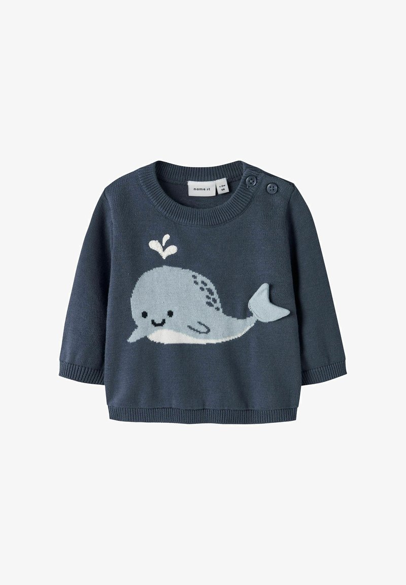Pull bébé bleu marine à manches longues, boutons sur l'épaule, avec un motif de baleine souriante bleu clair soufflant de l'eau sur le devant.