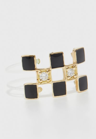 Gold-tone ring featuring black square enamel accents and two clear stones in a geometric pattern with an open band design.